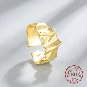 Macro detail of 925 sterling silver ring with irregular gold wave texture and hallmark