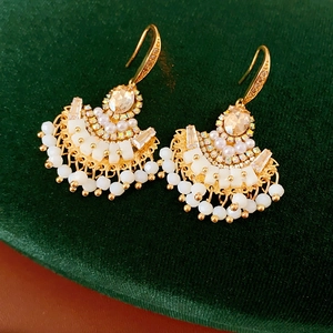 Vue détaillée de boucles d'oreilles en éventail avec cristaux de champagne et perles