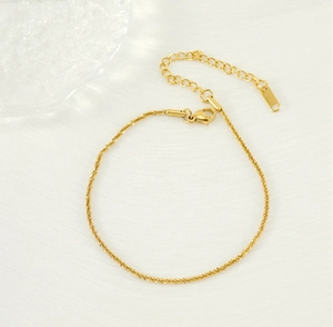 Detail of shimmering gold plated stainless steel anklet with adjustable extension chain