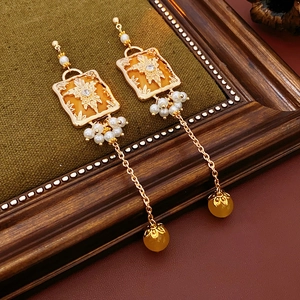 Detail of vintage gold maple leaf earrings with pearls and amber beads on velvet