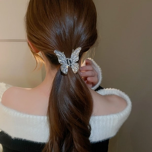 Detailed back view of a silver butterfly claw clip with rhinestones in a low ponytail