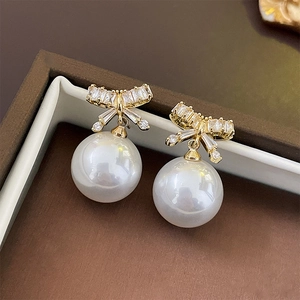 Elegant bow knot earrings with white faux pearls and cubic zirconia in a jewelry box