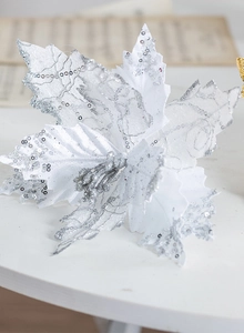 Gros plan d'une fleur de Noël en velours blanc avec paillettes d'argent pour décoration