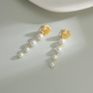 18K gold plated shell earrings with graduated white pearls and long tassels on grey
