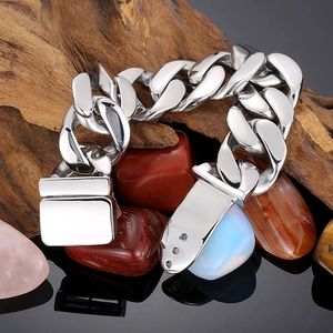 Détails du bracelet chaîne gourmette polie en argent avec fermoir carré sur bois naturel