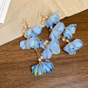 Détail macro de fleurs en tissu bleu avec glands de perles sur crochets dorés