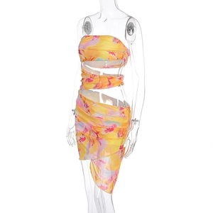 Détail de robe bustier fleurie jaune avec découpes à la taille et ourlet asymétrique