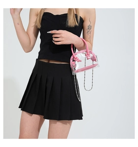 Détail d'un sac à main rose en PVC transparent avec bandoulière chaîne et design rond
