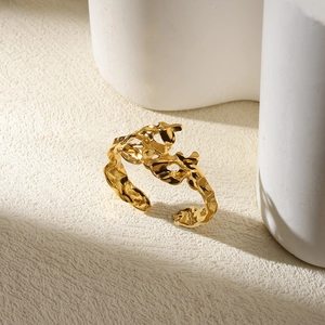 Detailed close-up of golden irregular lava texture ring on a minimalist stone display