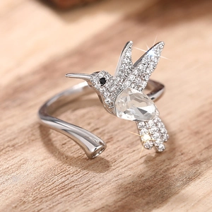 Macrodetail van kolibrie-ring met peervormige steen en zirkonia op hout