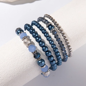 Dettaglio del set di 5 bracciali multistrato con cristalli blu e perle su espositore