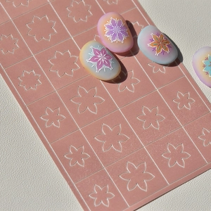 Gros plan de pochoirs à ongles fleurs roses avec des exemples de manucure florale colorée
