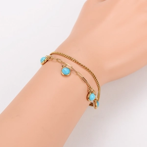 Gold double-layer stainless steel bracelet with blue turquoise charms on model wrist