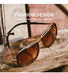 Close-up of tortoise shell sunglasses with gold double bridge on a rustic wooden beam