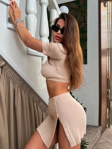 Detalle del conjunto de punto beige con top corto y falda con botones y abertura lateral