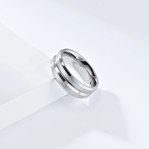 Brushed stainless steel ring with a polished groove on a minimalist geometric display