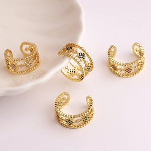 Close-up of gold-plated star rings with colorful zircon crystals on white shell