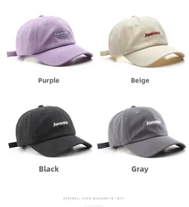 Detalle de letras bordadas en gorras de algodón en colores púrpura beige negro y gris