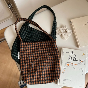 Close-up of retro plaid wool handbags in green and colorful houndstooth woven fabrics