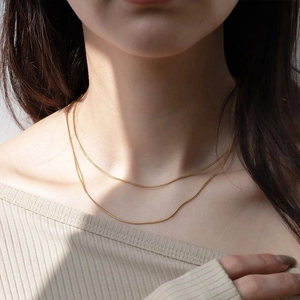 Nahaufnahme einer minimalistischen zweilagigen Gold-Schlangenkette aus Titanstahl für Damen