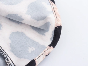 Macro shot of abstract leopard print fabric with black stitched edge detailing