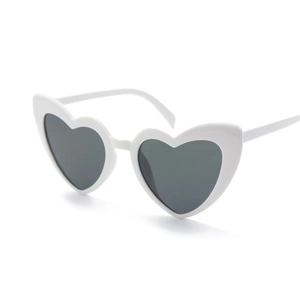 Front view of stylish white heart-shaped sunglasses with dark lenses for parties