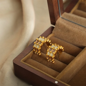 Gold-plated C-shaped hoop earrings with colorful enamel grid design in a jewelry box
