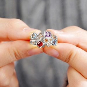 Detalle de piedras geométricas multicolores en un anillo bohemio plateado