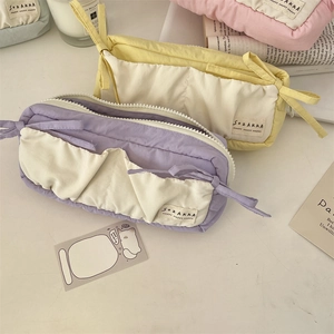 Quilted fabric stationery bag with white pocket and ribbon bow in pastel colors