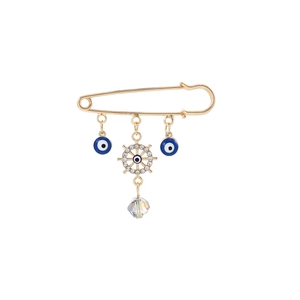 Detail of gold evil eye safety pin brooch with crystal ship wheel and blue bead charms