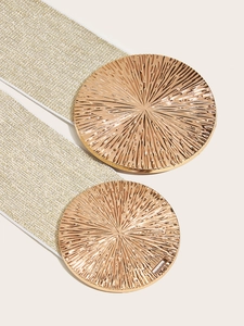 Macro shot of gold sunburst round buckles and woven elastic wide waist belt for women