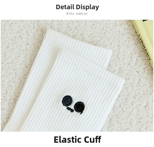 Close-up of white ribbed crew socks with cute black embroidery on high-elastic cuffs
