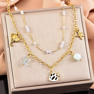 Detail of double-layer gold necklace with starfish elephant pendants and blue beads