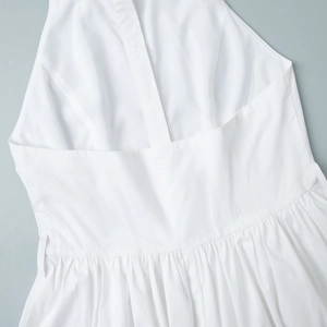 Détail de la robe blanche dos nu avec taille plissée et texture de tissu en coton fin
