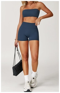Detail of high-waist yoga shorts and strapless sports top in matte navy fabric