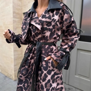 Dettaglio del trench leopardato con risvolti in pelle nera e cintura in vita