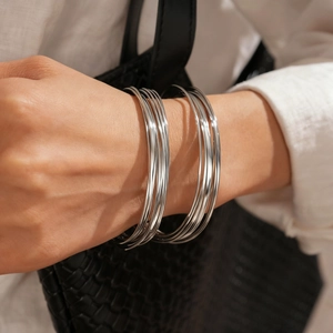 Close-up of elegant silver geometric twisted cuff bracelet worn by a model