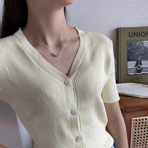 Minimalist S925 silver snake chain necklace with five round beads on a cream knit cardigan