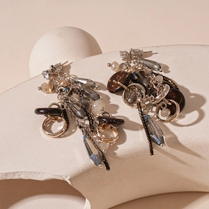 Detailed view of vintage geometric tassel earrings with zircon and wood accents on stone