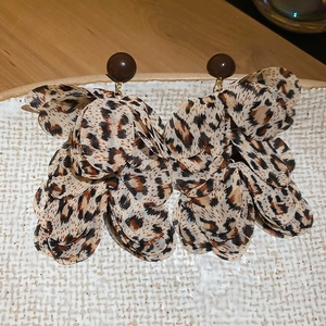 Detailed close-up of leopard print fabric flower petals on a round stud earring