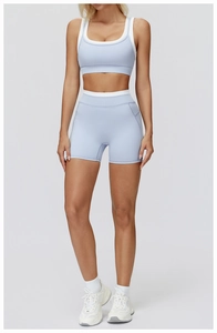 Detail view of high-waist light blue yoga shorts and matching sports bra with white trim