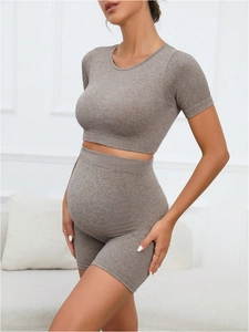 Two-piece seamless maternity workout set featuring high-waist yoga shorts and crop top shirt
