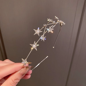 Detail showing metallic star headband with sparkling rhinestones and imitation pearls