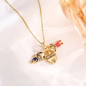 Macro shot of gold necklace featuring boy, girl, and heart charms on white fabric