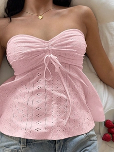 Detailed view of pink tube top with hollow out embroidery and drawstring bow decoration