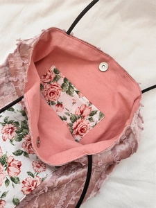 Detailed interior of a pink velvet lace tote bag with floral print and magnetic clasp