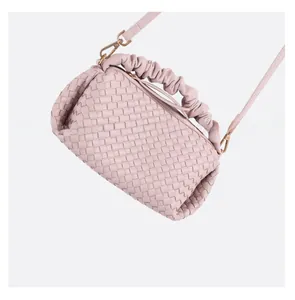 Close-up of pink woven handbag featuring scrunchie handle and gold metal hardware detail