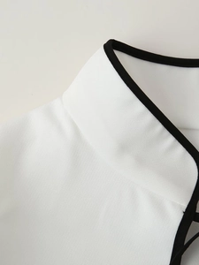 Close-up of white dress collar with black trim showing fine stitching and fabric texture