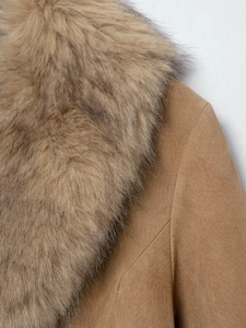 Close-up of brown suede jacket showing fluffy faux fur collar and textured fabric detail