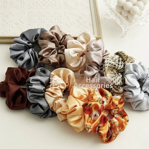 Close-up of assorted colorful satin scrunchies with silky texture and floral patterns